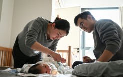 Wang Yifan (left) says paediatrician avatars helped answer questions about her baby, reducing trips to hospital