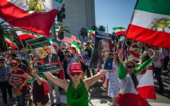 A woman holds pictures of Reza Pahlavi - the son of Iran's former Shah - and US President Donald Trump as members of the Iranian community celebrate in Los Angeles