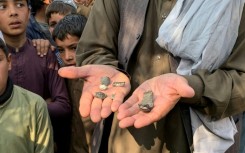 An Afghan man shows mortar shell remains in the Ghani Khel district of Nangarhar province on March 1, 2026 amid ongoing cross-border fighting between Afghanistan and Pakistan.
