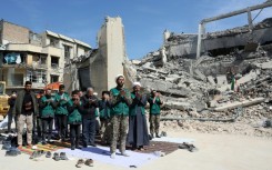 Iranian clerics and volunteers from the Bsij military who are helping clear the streets pray next to the rubble of a police station destroyed in airstrikes in central Tehran, on March 4, 2026.