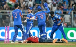 India's players celebrate after the run out of Jacob Bethell for 105 in the final over