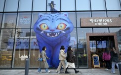 People walk past a glass wall displaying animal characters from Netflix series "Kpop Demon Hunters" at a bakery in Seoul on March 17, 2026