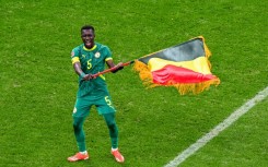 Idrissa Gueye waves the Senegal flag after his side beat Morocco on the field in the in the Africa Cup of Nations final in January