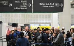 Travelers wait in line at a TSA security checkpoint at George Bush Intercontinental Airport in Houston, Texas on March 20, 2026