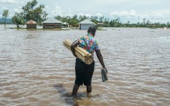 A woman in Kenya's Nyakach region wades through flooding triggered by torrential rain