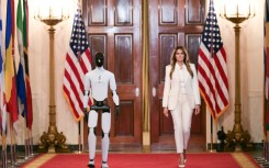 US First Lady Melania Trump walks with a humanoid robot as she arrives for the Fostering the Future Together Global Coalition Summit in the White House
