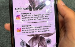 A teenager holds a phone displaying a message from social media platform Instagram after the account was locked for age verification in Australia