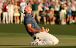 Rory McIlroy celebrates winning the 2025 Masters after falling to his knees on the 18th green having just completed a career grand slam