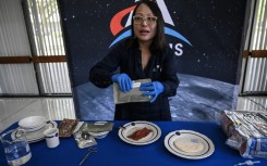 Xulei Wu, a NASA food scientist, displays dishes that were part of the Artemis II crew's meals