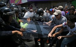 Opponents to the government of Venezuelan interim President Delcy Rodriguez clash with the police as they demonstrate in demand of salary and pension raises in Caracas on April 8, 2026