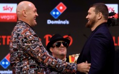 Britain's two-time former world heavyweight champion Tyson Fury (L) faces off with Russia's Arslanbek Makhmudov during a press conference ahead of their bout in London