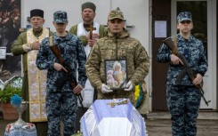 Ukraine soldiers at the funeral of a child killed in a Russian drone attack on a multi-storey residential building in Odesa