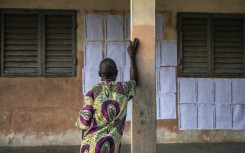 A voter looks for his name on the electoral roll at a primary school serving as a polling station in Cotonou, Benin