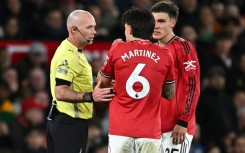 Referee Paul Tierney speaks with Manchester United defender Lisandro Martinez (C)