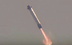 This screen grab taken from a Blue Origin broadcast shows the booster of Blue Origin's New Glenn rocket preparing to land on a floating platform in the Atlantic Ocean