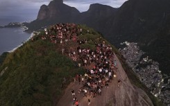 Tourists watch the sunrise from Morro Dois Irmaos above the Vidigal favela