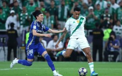 FC Machida Zelvia's Japanese defender Hotaka Nakamura (L) fights for the ball with Al Ahli's Brazilian forward Galeno