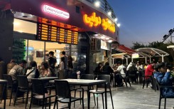 Iranians gather at an eatery in northwestern Tehran. Despite an outward appearance of normality, many are under severe financial strain