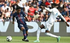 Ibrahim Mbaye (L) of Paris Saint-Germain and Abdoulaye Faye of Lorient fight for the ball.