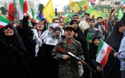 A young enthusiast in military attire holds a mock rifle during a rally to show support for Iran's new supreme leader, Ayatollah Mojataba Khamenei, in Tehran