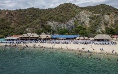 Aerial view of Playa Blanca beach in the Colombian region of Santa Marta, where mountains sweep down through jungle to the Caribbean