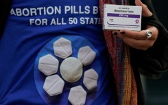 An abortion rights activist holds a box of mifepristone during a rally in front of the US Supreme Court on March 26, 2024, in Washington, DC