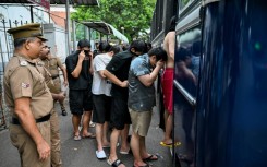Prison guards escort detained Chinese nationals suspected of running cyberscams in Sri Lanka