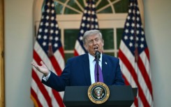 US President Donald Trump gestures prior boarding Air Force One at Joint Base Andrews en route to China