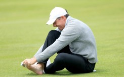 Second-ranked Rory McIlroy of Northern Ireland checks on a blister on his right pinky toe on the 18th hole during a practice round on the eve of the opening round of the PGA Championship at Aronimink