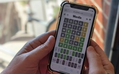 This photo illustration shows a person playing online word game Wordle on a mobile phone