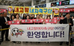 South Korean activists hold banners welcoming North Korea's Naegohyang Women's FC at Incheon International Airport
