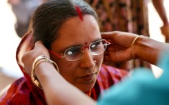 Weaver Savita Maharana tries on spectacles at GoodVision India – Care Netram charity's eye screening camp in Cuttack's Maniabandha village