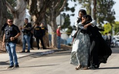 Two women react following a shooting at the Islamic Center of San Diego, in southern California, on May 18, 2026 that left three people dead