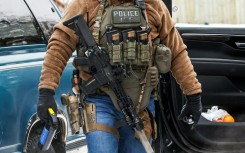 A masked federal agent from Immigration and Customs Enforcement (ICE) patrols in Minneapolis, Minnesota, in February 2026