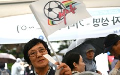 A South Korean football supporter waves a flag of North Korean team Naegohyang Women's FC