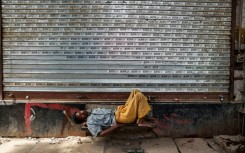 A man takes a nap in front of a closed shop on a hot summer day in Varanasi, in India's Uttar Pradesh, on May 23, 2026