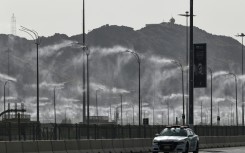 A police car drives past water-mist fans in Mecca ahead of the hajj pilgrimage when temperatures could reach 47 degrees Celsius