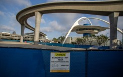 A closed construction area is seen near The SkyLink Automated People Mover line and the Theme Building and Air Traffic Control Tower at Los Angeles International Airport