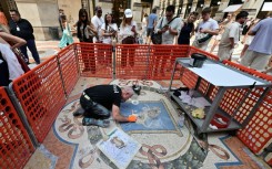 Restorer Gianluca Galli works on the mosaic of the bull during the restoration in the Galleria Vittorio Emanuele II