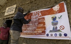 A man hangs an Ebola awareness banner in the Kigonze displaced persons camp in Bunia, in the eastern DRC