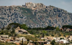 Destroyed buildings are pictured in the village of KfarKila in southern Lebanon as seen from across the border in the Upper Galilee region of northern Israel on May 29 with the Beaufort Castle pictured in Lebanon in the background