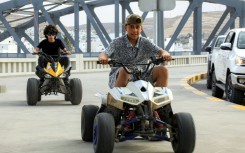 Children ride all-terrain vehicles (ATVs) along a pedestrian pavement in Derna