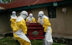 Members of a Congolese Red Cross team carry the coffin of a woman suspected of having died from Ebola in the eastern city of Bunia