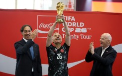 Canada's Prime Minister Mark Carney holds aloft the World Cup trophy next to FIFA President Gianni Infantino in May
