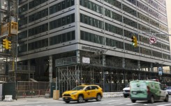 Cars drive past 77 Water Street, a former office building being transformed into luxury rental apartments in the Financial District of New York in April 2026