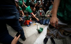 People in Mexico City gather around Merlin, a duck who has become a huge star thanks to the World Cup