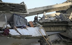 A woman gestures for help atop an apartment building following the earthquakes that hit Venezuela's La Guaira state particularly hard