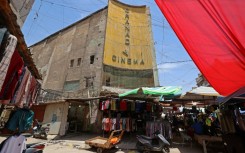 Street vendors gather outside the faded facade of the Granada Cinema, an early 1940s landmark, in the Bab al-Sharqi district of central Baghdad