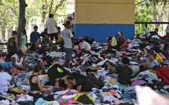 People sift through clothing at a donation center in Caraballeda, La Guaira state