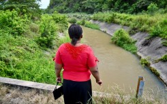 Eva Sevillano, a resident of the Nueva Prosperina neighborhood of Ecuador's port Guayaquil, stands at the waterway known as the Canal de la Muerte (Death Canal)
